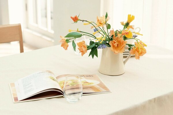 Sur la table, un vase avec des fleurs et un livre ouvert