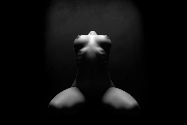 Pose with bare breasts on a black background