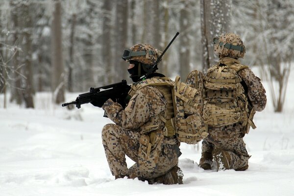 Soldados con armas en el bosque de invierno