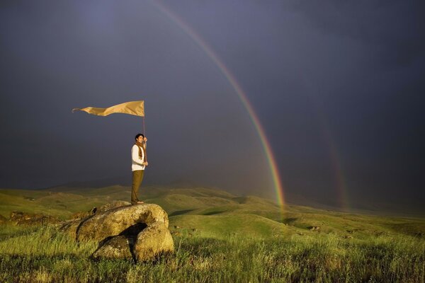 A man with a flag on a stone