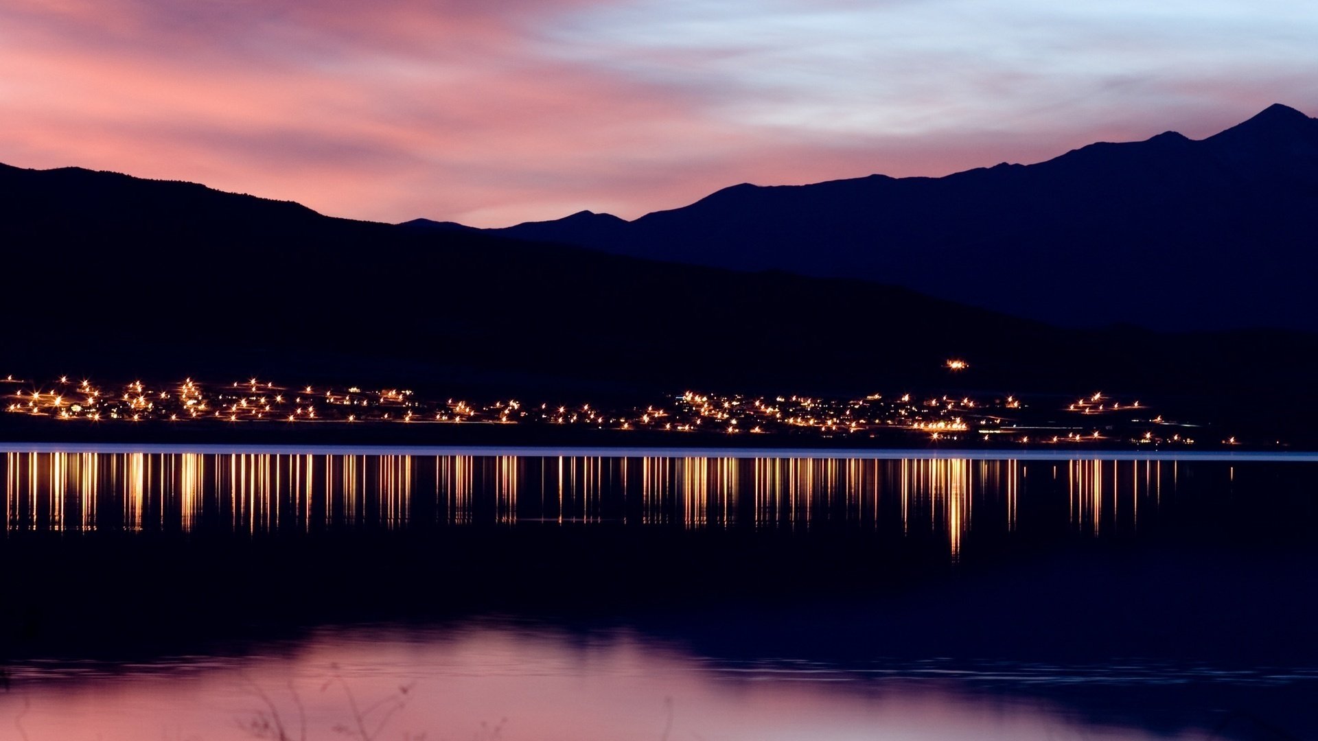 paisaje noche montañas cuerpo de agua puesta de sol horizonte luces