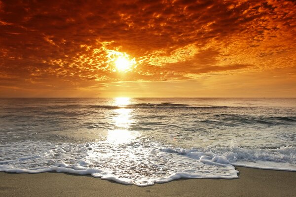 Puesta de sol en la playa. Nubes sobre el océano vespertino