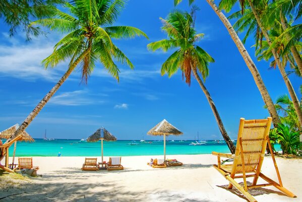 Spiaggia azzurra con sabbia bianca e sedie a sdraio