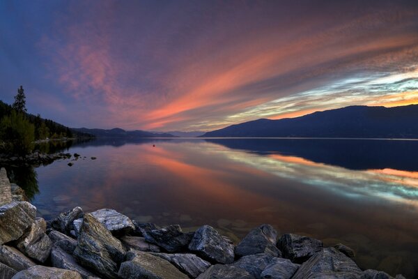 Coucher de soleil rouge sur le lac dans les montagnes