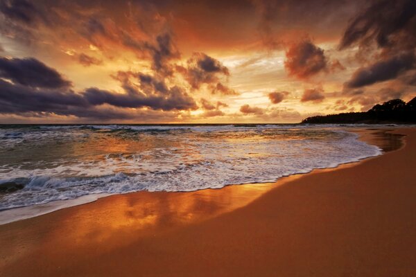 Strand am Meer bei rotem Sonnenuntergang