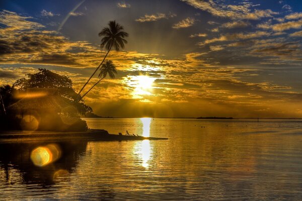 Puesta de sol en el mar resplandor del sol y bungalows