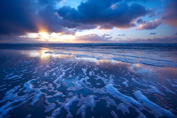 The waves frothed from the surf at a gray-purple sunset