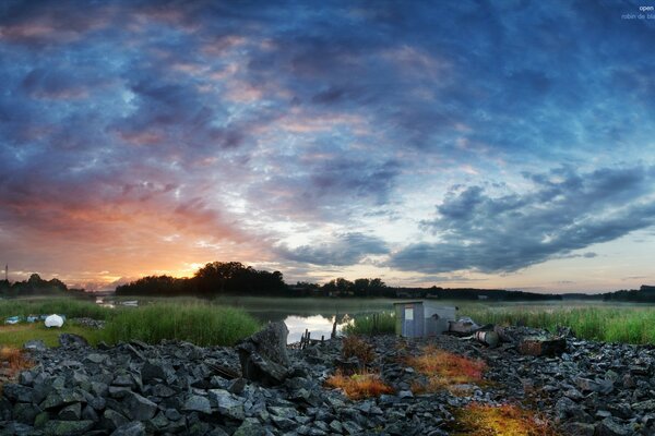 Beau coucher de soleil sur le lac et le champ