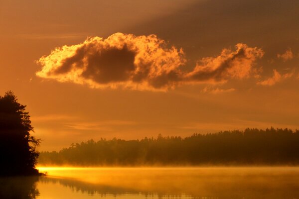 Puesta de sol naranja en el lago. Niebla sobre el lago