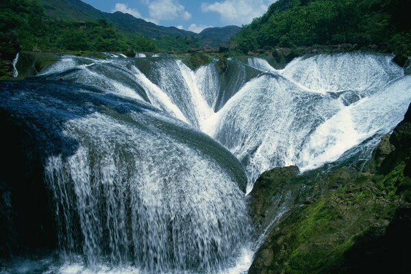 Wasserfall-Landschaft mit grünen Steinen