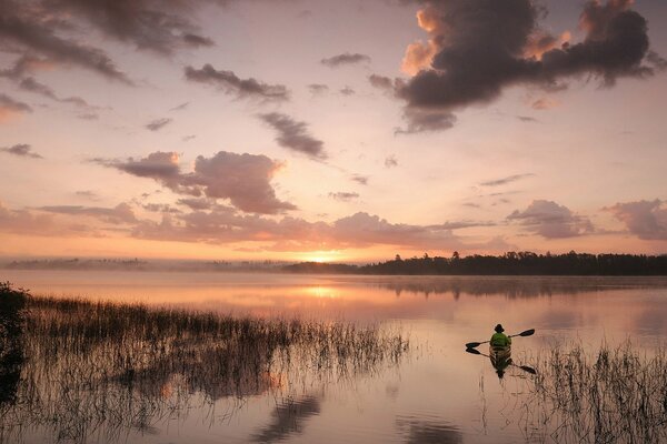 Fisherman in a boat at sunset