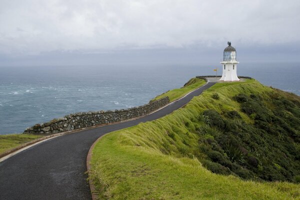 Route du phare sur un promontoire avec des pentes vertes