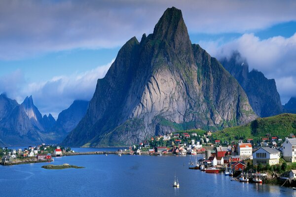 A city on the shore of a lake at the foot of high mountains. Beautiful landscape