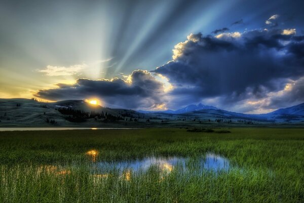 Sunset rays of the sun on the background of dark clouds