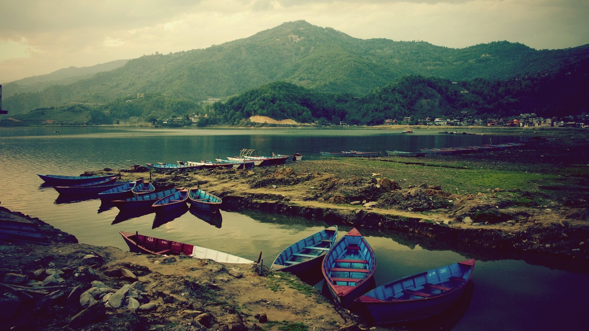 muelle barcos lago montañas