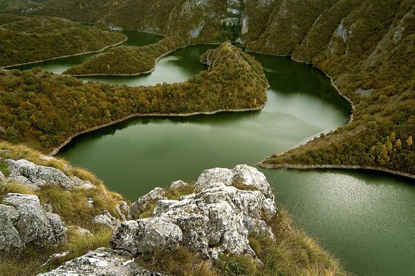 Grüner Fluss zwischen bewaldeten Bergen