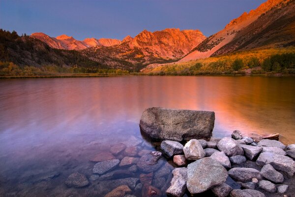 Lago limpido tra le montagne al tramonto