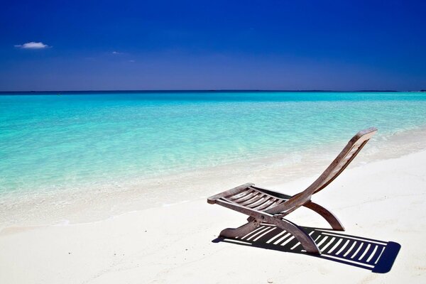 Chaise longue on the azure coast of the ocean