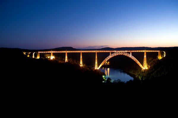 Die ganze Brücke leuchtet mit hellen Lichtern über dem Fluss