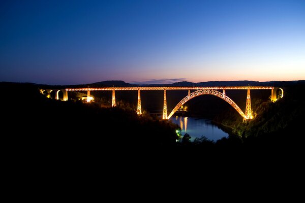 The bridge is all ablaze with bright lights over the river