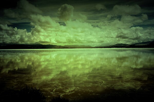 Greenish clouds are reflected in the lake