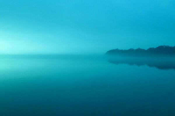 El lago brumoso refleja el cielo