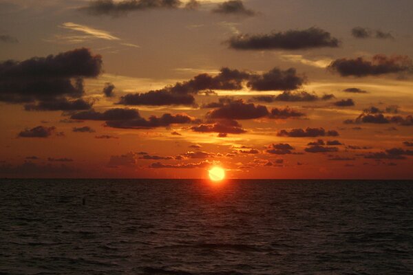 Il sole tramonta in mare. Nuvole nei raggi del tramonto