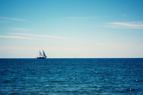 A drifting yacht on the sea horizon