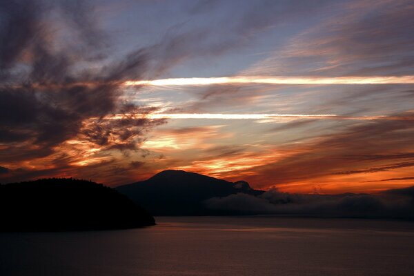 Tramonto sulle montagne e sulla superficie dell acqua