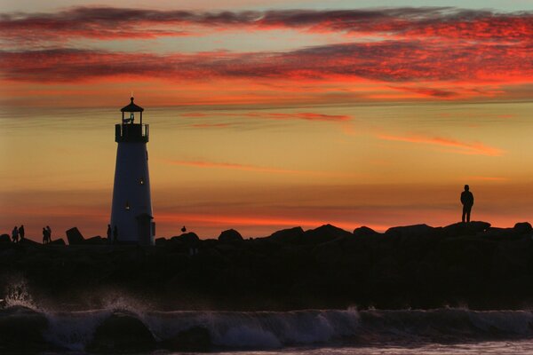 Lighthouse on the seashore at sunset