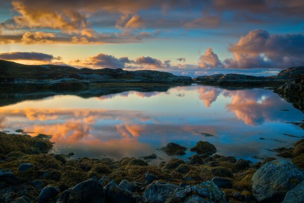 A orillas de un lago en Noruega. Reflejo de la puesta de sol en el agua