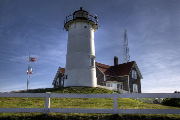 Lighthouse in the USA gray sky on a background of green grass