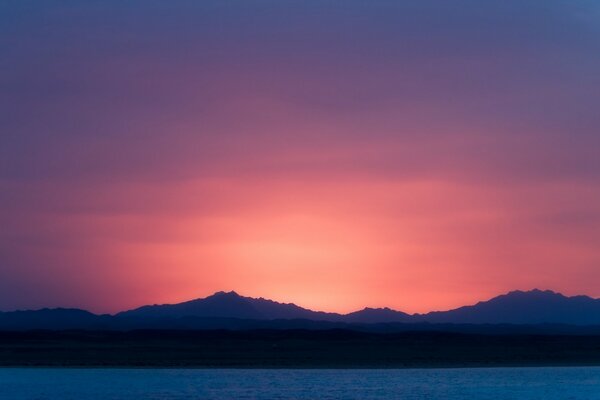 Lila Sonnenuntergang und Silhouetten der Berge