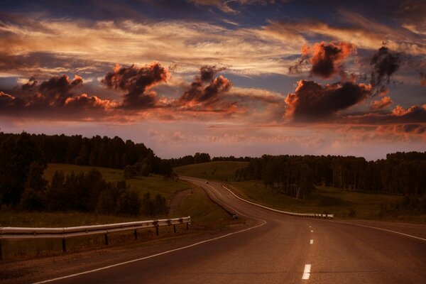 A road with a crimson sky and the horizon is visible
