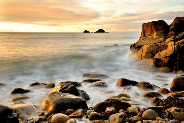 Muchas piedras en la orilla del mar