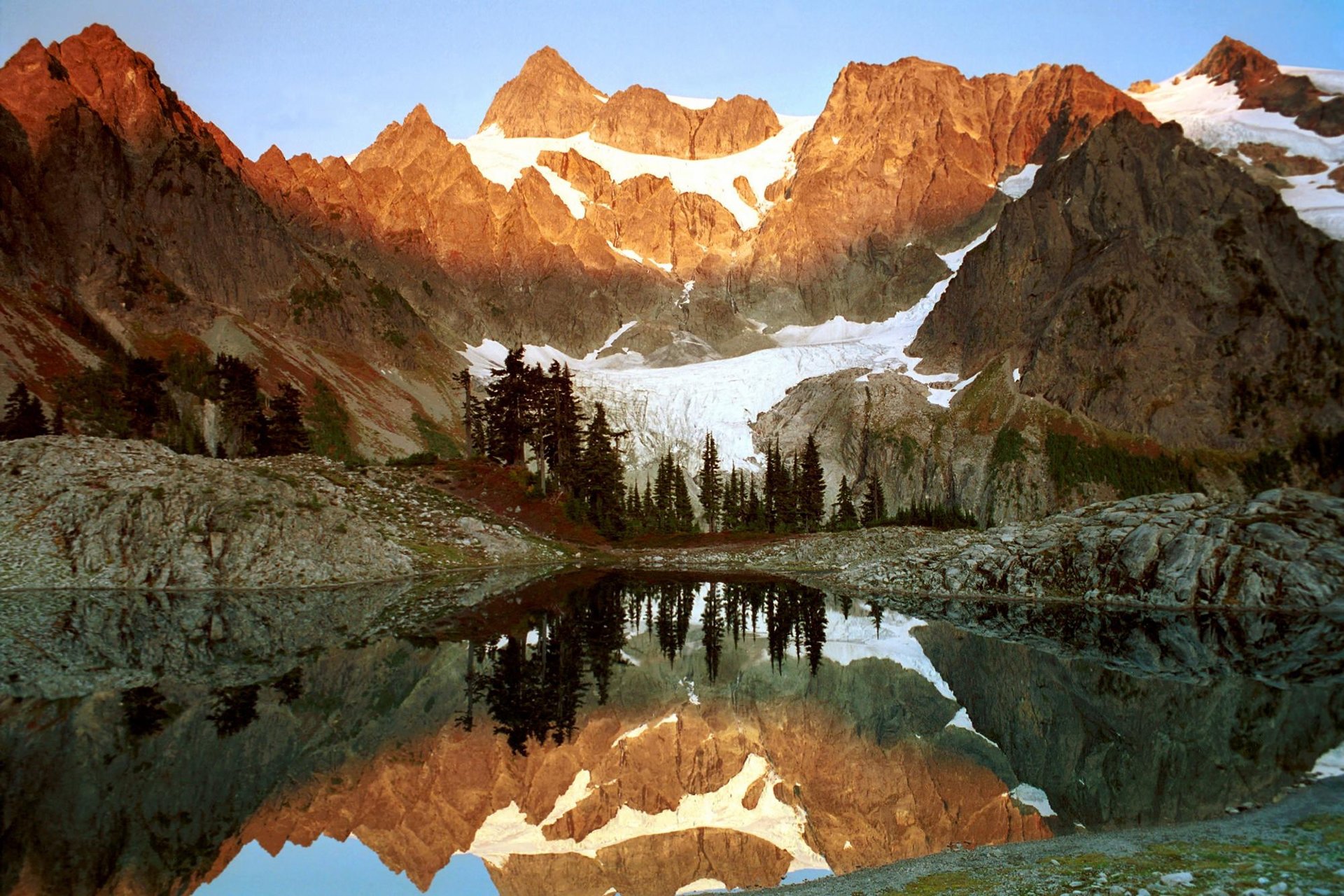 agua reflejos montañas hielo glaciar árboles pinos roca