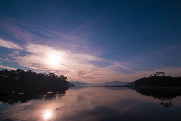 Alba sul lago nella foresta