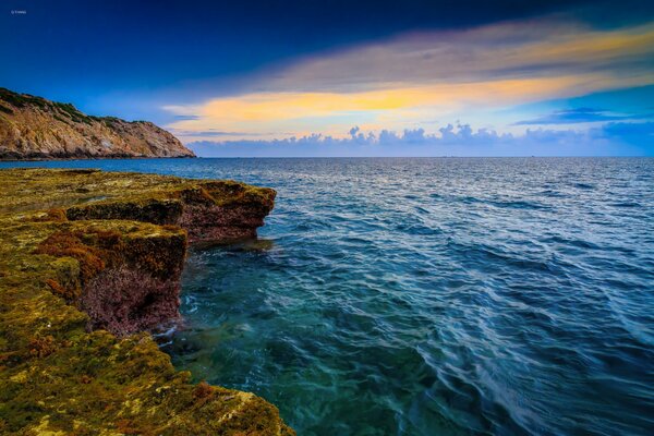 Paesaggio marino con roccia al tramonto