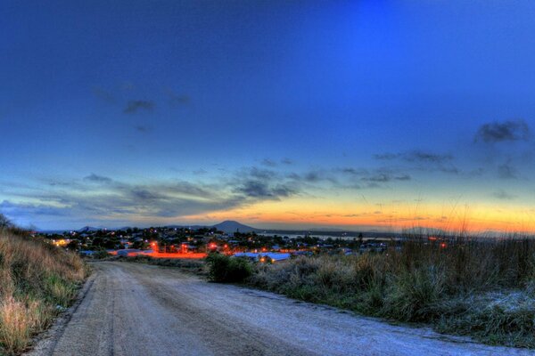 Evening road leading to the glowing city