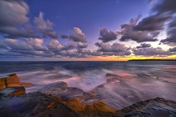 Spiaggia di pietra e cielo al tramonto con nuvole