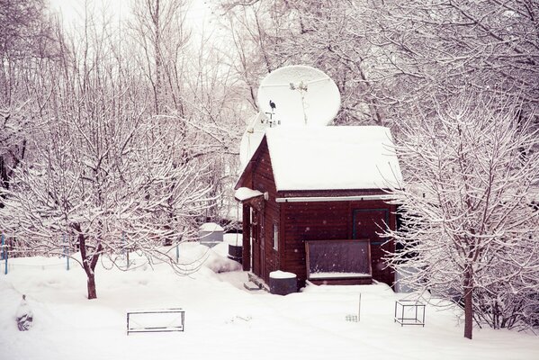 Casa en la nieve en el patio de invierno