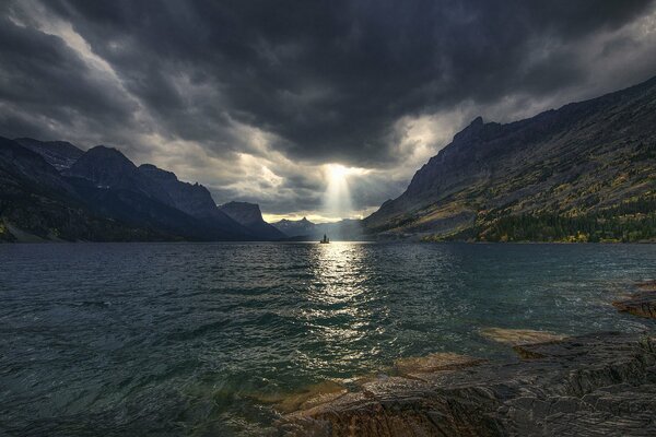 Die Sonnenstrahlen brechen durch dunkle Wolken