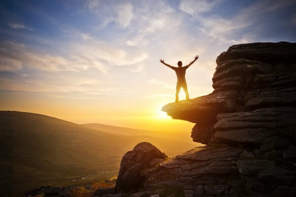 Photo of a man on a cliff. Sunset photo in nature