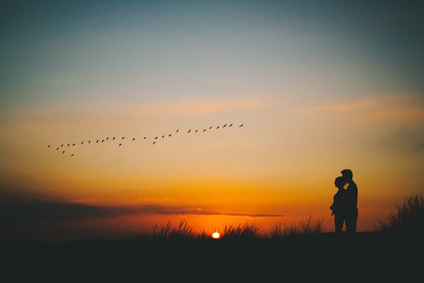 Silhouette der Liebenden auf Sonnenuntergang Hintergrund