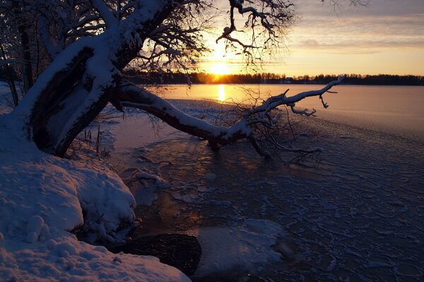 Sonnenuntergang am schneebedeckten Fluss