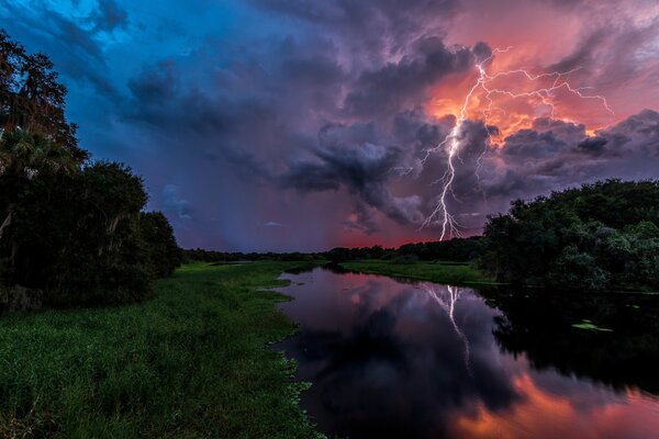 Paisaje tormenta cerca del río y el bosque