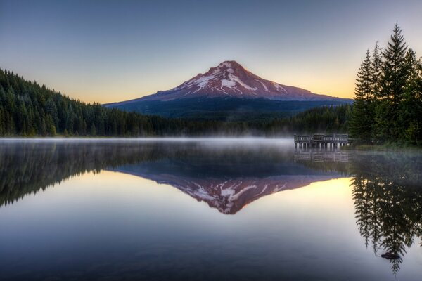 El bosque y las montañas se reflejan en el agua del lago