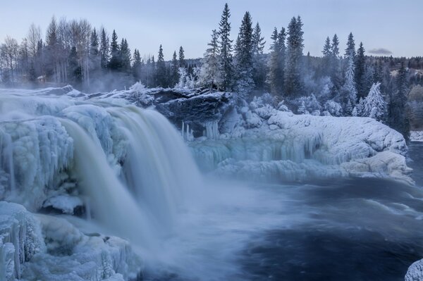 Cascada de hielo de invierno hecha de nieve