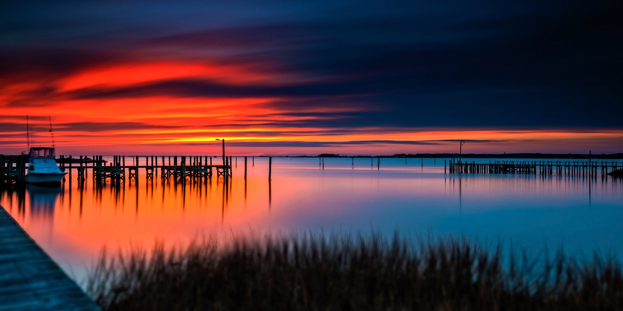 orange burst sunset water surface boat