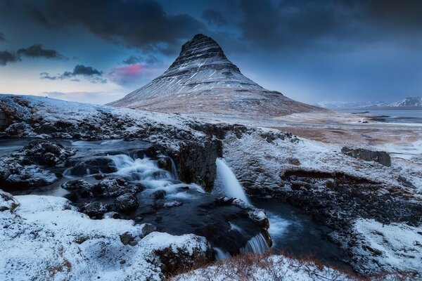 Roches enneigées et volcan en Islande